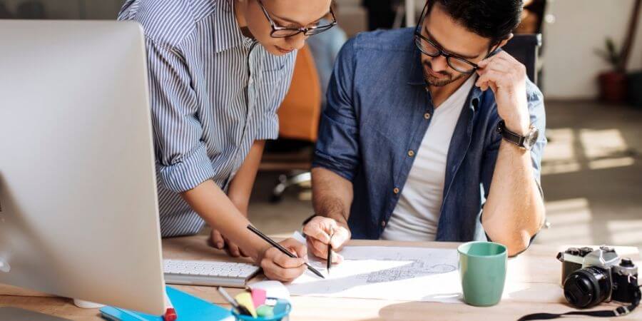 2 people working together with pencils