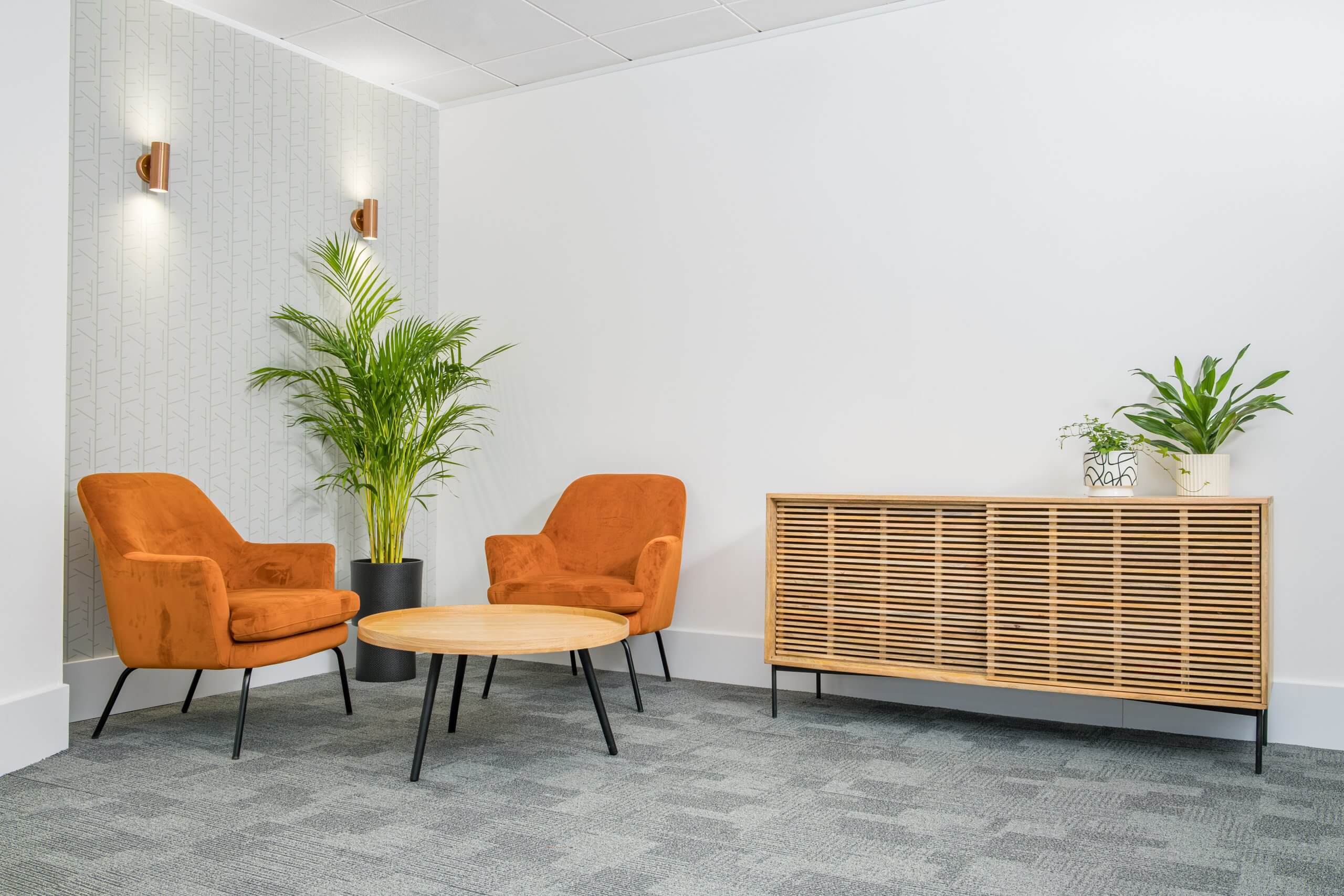 An office lounge with two chairs, a coffee table and a side table. Located in an office floor.