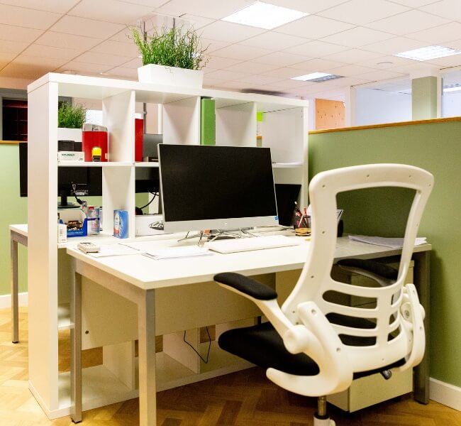 coworking space showing a desk with a chair and screen