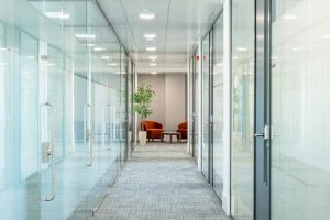 Modern office corridor in Woking with glass doors, long hallway, and breakout space at the end.