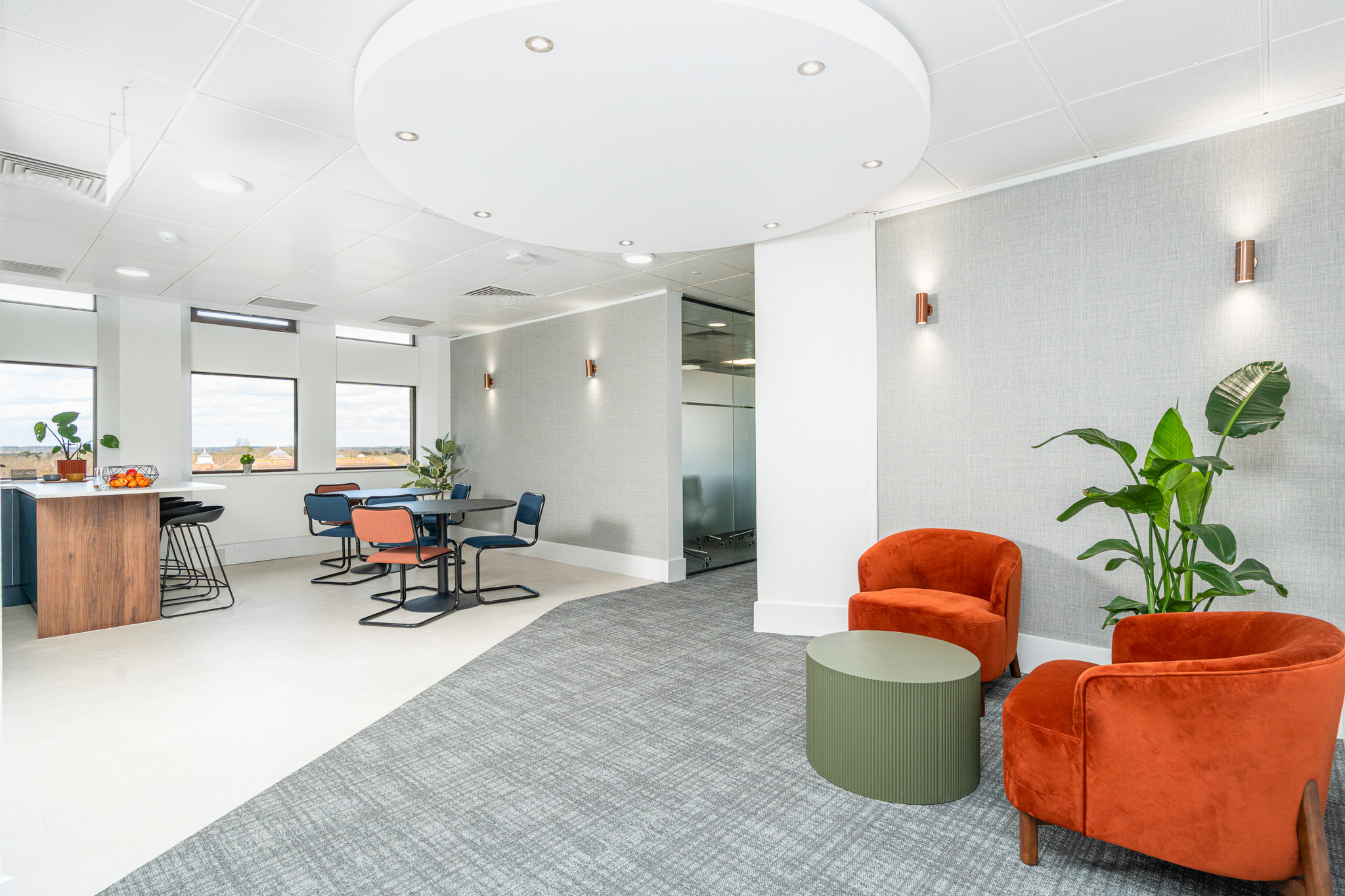 Office kitchenette with chairs, table, and corridor.